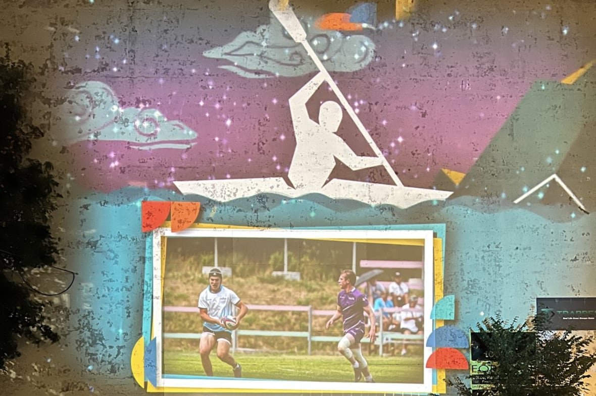 A light display projected on a building in St. John's, N.L. featuring rugby players and a kayak competitor.