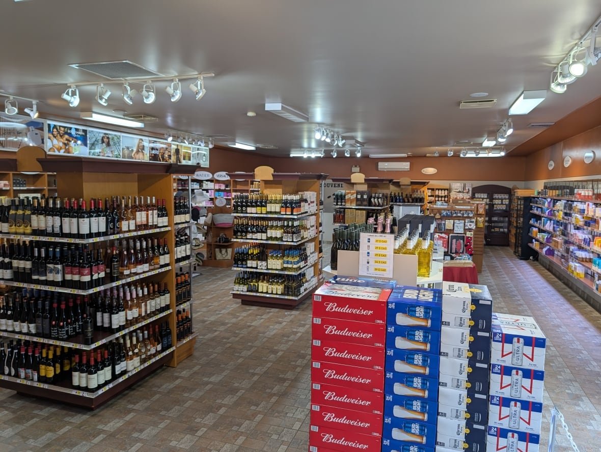 An empty, brightly lit store full of shelves lined with booze.