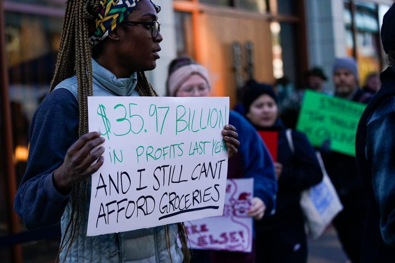 default-155 Protester holding a sign referencing Starbucks profits.