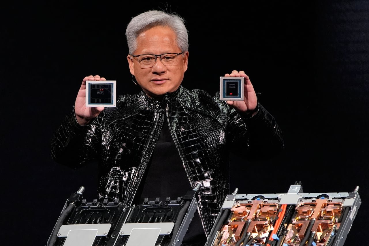 default-205 A man in glasses showcasing computer graphics processing unit and central processing unit, wearing a crocodile leather jacket.